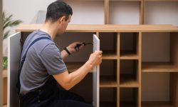 custom-furniture-delivery-and-assembly-master-attaching-white-door-to-wooden-cabinet-e1697706138100.jpg